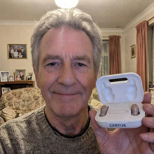 A man in his seventies holding the open Certus case in his living room